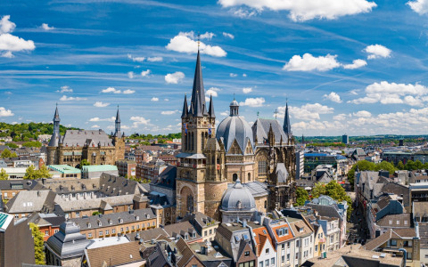 Luchtzicht op de Dom van Aken en het stadsbeeld onder een blauwe hemel met mooie wolken.