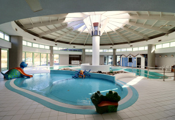 Piscine intérieure d'un hébergement glamping avec des personnages ludiques et beaucoup de lumière