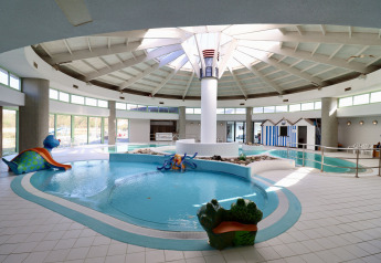 Indendørs swimmingpool i et glamping-opholdssted med børnevenlige figurer og naturligt lys
