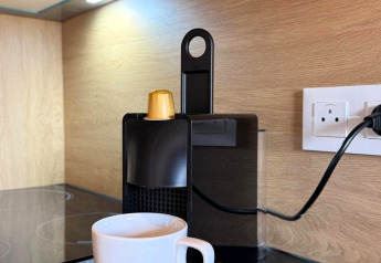 Macchina da caffè con capsule dorate e tazza bianca presso Mobi Lodge, Arden Parks Tulderheyde, Belgio.