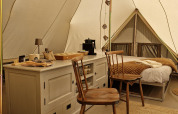 Interno di una tenda Bell a Thuysgrond nei Paesi Bassi, con arredi in legno e decorazioni accoglienti.