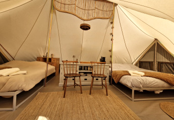 Interieur van de Bell tent tipi-tent bij Thuysgrond in Nederland met twee bedden en houten meubels.