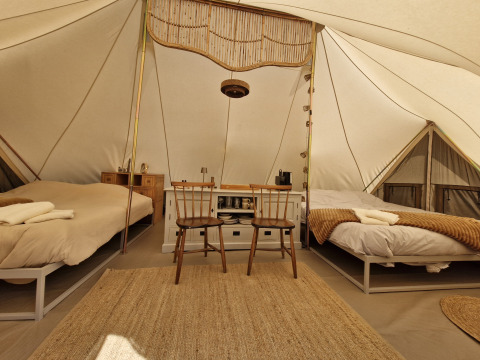 Interieurfoto van Bell tent tipi-tent bij Thuysgrond in Nederland met twee bedden en houten meubels.
