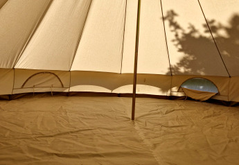 Binnenin een Basecamp Bell tipi tent bij Thuysgrond, Nederland, met centrale paal en zichtbare schaduwen.