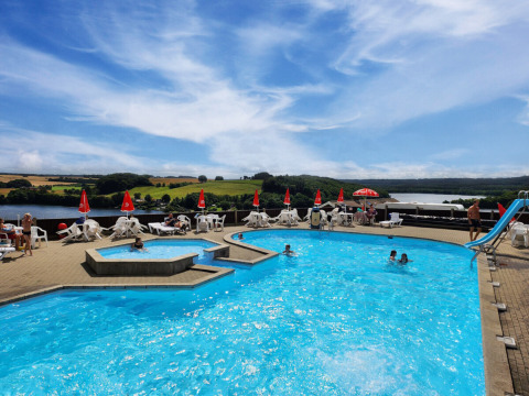 Piscina all'aperto con vista su lago e colline al Terrassen Camping, Regione Centrale della Danimarca.