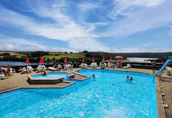Buitenzwembad met uitzicht op meer en heuvels bij Terrassen Camping, Centraal-Denemarken.