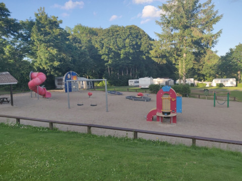 Legeplads med rutsjebane og gynger på Terrassen Camping i Region Midtjylland, Danmark, omgivet af natur.