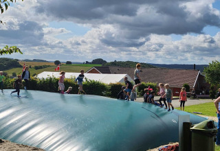 Bambini che giocano su un grande cuscino gonfiabile a Terrassen Camping nella regione centrale della Danimarca.