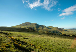 Hügelige Landschaft bei Saint-Rémy-sur-Durolle in Auvergne-Rhône-Alpes, Frankreich, bei klarem Himmel.