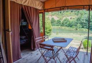 Vista dalla Tiny House Galli all’Onlycamp Camping Le Lac de Roybon, Francia, con terrazza e lago.