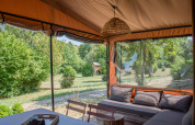 Vista da Tiny House Galli all'Onlycamp Camping Le Lac de Roybon con salotto accogliente e natura intorno.