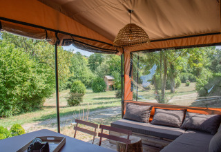 Vista da Tiny House Galli all'Onlycamp Camping Le Lac de Roybon con salotto accogliente e natura intorno.