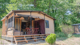 Tiny House Galli, una casa nella natura con veranda e mobili esterni, immersa in un verde bosco.
