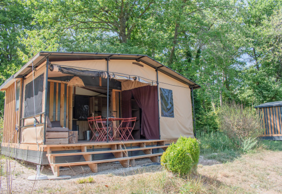 Tiny House Galli, una casa nella natura con veranda e mobili esterni, immersa in un verde bosco.