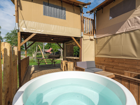 Boomhut tent met bubbelbad bij Holiday park Mölke in Nederland, ideale plek voor ontspannen buiten.