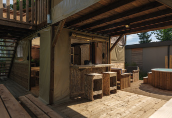 Treehouse tent with bubble tub at Holiday park Mölke, Netherlands. Rustic wood furniture and outdoor space.