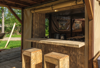 Rustieke houten bar met krukken in een boomhuttent in Holiday park Mölke, Nederland.