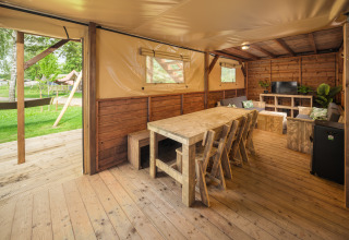 Interior of a treehouse tent with rustic wood furniture at Holiday park Mölke, Netherlands.