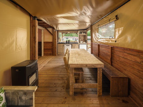 Interieur van Treehouse tent met houten eettafel bij Holiday park Mölke in Nederland.
