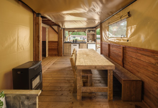Interieur van Treehouse tent met houten eettafel bij Holiday park Mölke in Nederland.