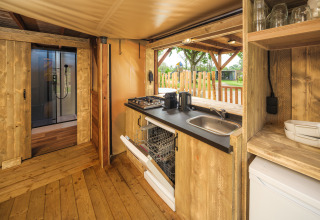Interior of a treehouse tent featuring wooden design, kitchen area, and view at Holiday park Mölke.