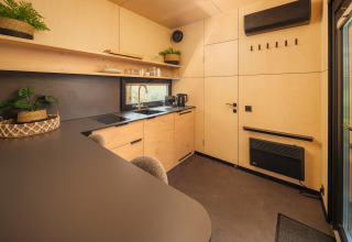 Moderne keuken in River Mirrorlodge bij Holiday park Mölke, Nederland, met hout en donkere accenten.