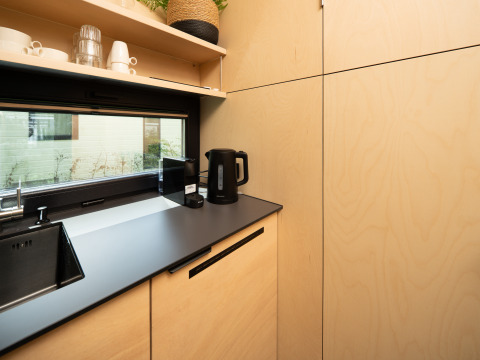 Moderne kitchenette in River Mirrorlodge bij Holiday park Mölke, Nederland, met waterkoker en kopjes.