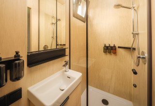 Moderne badkamer met douche en wastafel bij River Mirrorlodge, Holiday park Mölke, Nederland.