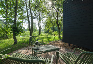 Buiten zitgedeelte bij River Mirrorlodge in Holiday park Mölke, Nederland, omringd door groen.
