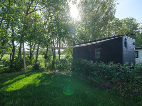 River Mirrorlodge bij vakantiepark Mölke in Nederland, omgeven door bomen en groene natuur.