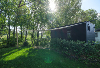 River Mirrorlodge bij vakantiepark Mölke in Nederland, omgeven door bomen en groene natuur.
