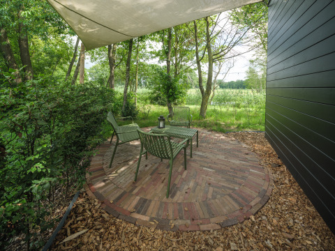 Buitenzitplek bij River Mirrorlodge, Holiday park Mölke, Nederland, met stoelen en een tafel.