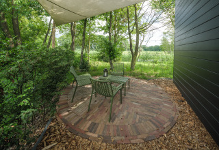 Buitenzitplek bij River Mirrorlodge, Holiday park Mölke, Nederland, met stoelen en een tafel.