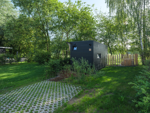 River Mirrorlodge bij Holiday park Mölke in Nederland, omgeven door bomen en groene natuur.