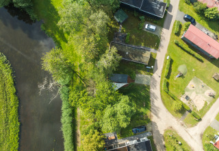 Luchtfoto van de River Mirrorlodge op vakantiepark Mölke in Nederland, naast een rivier en bomen.