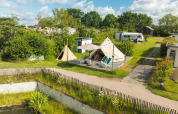 Teepeetent Blije haventent op Holiday park Mölke in Nederland, met groene omgeving en een camper in de buurt.