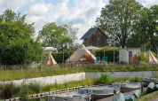 Zicht op boten en tipi-tenten bij «Blije haventent» op vakantiepark Mölke, Nederland, omringd door natuur.