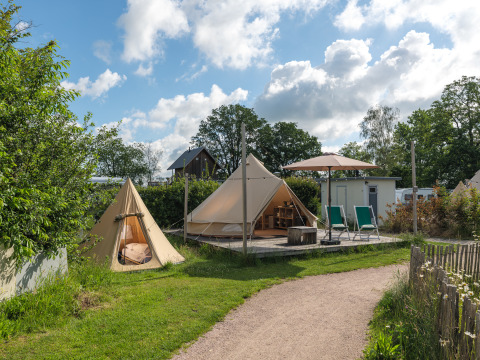 Moderne tipi-telte og afslapningsområde på Holiday park Mölke i Holland under en blå himmel.