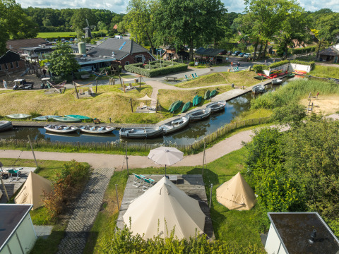 Udsigt over ferieparken Mölke i Holland med tipitelte, kanaler og både på en solrig dag.