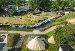 Vue depuis la tente tipi Blije haventent au parc de vacances Mölke, Pays-Bas, avec bateaux et nature.