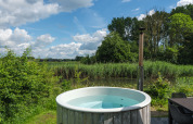 Vasca idromassaggio esterna alla River Cabin al Holiday park Mölke nei Paesi Bassi, tra natura e cielo.