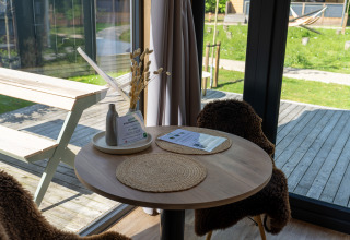 Coin repas chaleureux dans Tiny Home à Urban-Gardens Gent, Belgique, avec vue sur terrasse et jardin.