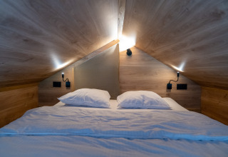 Accogliente camera mansardata con letto matrimoniale in Tiny Home a Urban-Gardens Gent, Belgio.