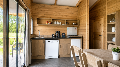 Vista interna della tenda safari Tenthouse al Camping 't Veld nei Paesi Bassi con cucina in legno.