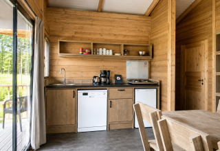 Vista interna della tenda safari Tenthouse al Camping 't Veld nei Paesi Bassi con cucina in legno.
