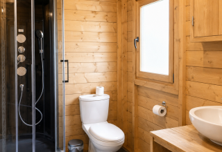 Bagno moderno in legno presso Tenthouse, Camping 't Veld, Paesi Bassi. Doccia, wc e lavabo visibili.