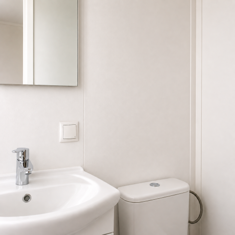 Bagno minimalista al Beach chalet di Camping 't Veld nei Paesi Bassi, con lavandino, specchio e WC.