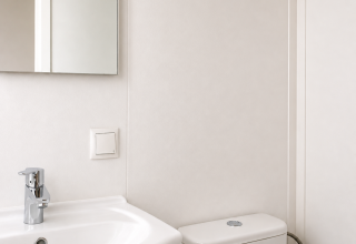 Baño minimalista en Beach chalet en Camping 't Veld, Países Bajos, con lavabo, espejo y váter.
