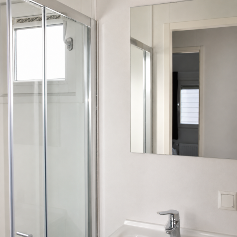 Salle de bain moderne avec douche en verre, lavabo blanc et miroir au Beach chalet du Camping 't Veld, Pays-Bas.