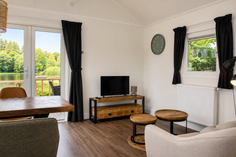 Soggiorno luminoso e moderno in chalet Beach House con vasca idromassaggio a Camping 't Veld, vista lago.